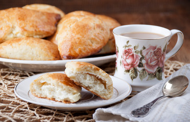 Cottage cheese pies in a plate and cup with coffee