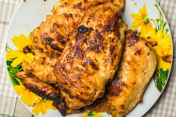 Dish of fried chicken breast fillet in a plate on the kitchen table.