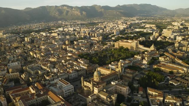 Cinematic flight early sunny morning over the Cattadrale Santa Vergine Maria Assunta, Palazzo dei Normanni, and Cappella Palatina, in the historic part of Palermo. Sicily, Italy. May 2019. Aerial shot