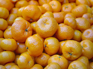 Fresh mandarin oranges ready for sale. Tropical orange fruits on market stall.