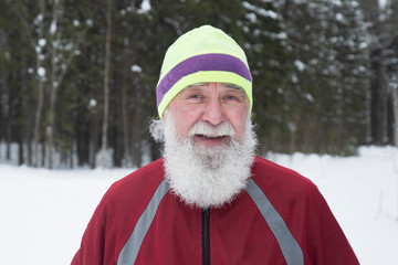 Fototapeta premium Portrait of an elderly man who runs in the woods. Active longevity.