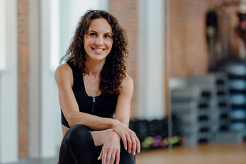 Portrait of happy smiling fitness woman sitting on bosu ball