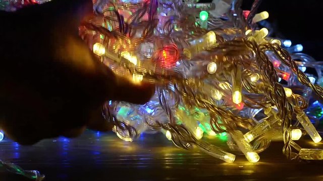 Multicolored Christmas garlands are tangled in chaotic