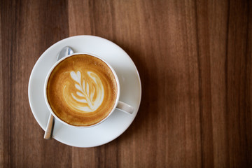 a cup of Latte art coffee on wood background