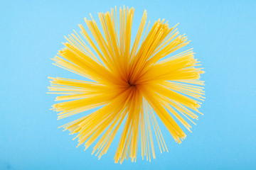 Pasta in the form of the sun on a blue background. The concept of photography.