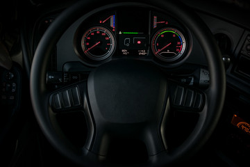 Dashboard with the control clocks of a lighted truck with the steering wheel in the foreground