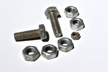 bolts and nuts of different sizes lie on a white background. top view.