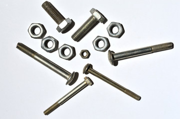 bolts and nuts of different sizes lie on a white background. top view.