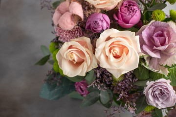 original bouquet of roses with brassica on a gray background. horizontal image, copy space, top view