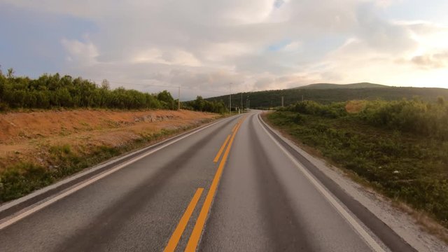 Driving a Car on a Road in Norway at dawn