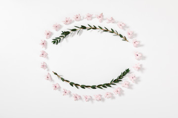 Modern composition of pink flowers and eucalyptus. Pattern made of eucalyptus branches and leaves, flowers on white background. Flat lay, top view, copy space