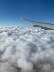wing of an airplane flying above the clouds