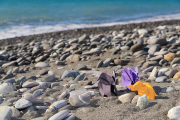 origami elephants made of colour paper on natural background with sea and beach. paper and nature conservation concept. family and childhood protect. mockup, copy space