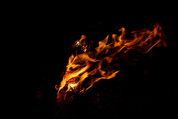 Lodernde Flammen eines romantischen Lagerfeuers beim Camping erhöhen Brandgefahr und Gefahr von...