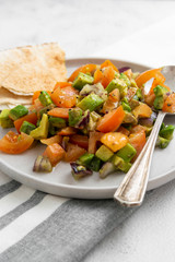 Avocado salad with tomatoes and red onions, flat lay vegan salad. Healthy vegan food.