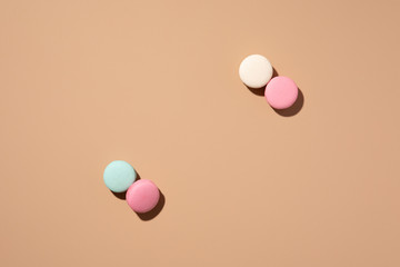 Mint, white and pink macaroons on beige background with shadows. Flat lay pattern, Pastel color. Top view layout