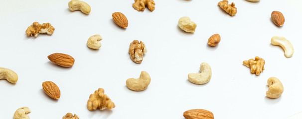 Isolated nuts pattern backdrop. Walnut, cashew, almond and hazelnut on white background. Top view.