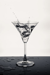  a glass of martini and splashes of liquid from an ice cube1