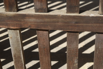 A fence of wood and a shadow on the floor