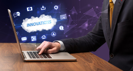 Businessman working on laptop with INNOVATIONS inscription, modern technology concept