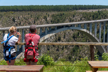 Bloukrans Bridge, Eastern Cape, South Africa. Dec 2019. Young couple wearing harnesses looking...