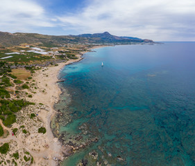 Panoramic aerial view of Falasarna on Crete island, Greece with turquoise water and sandy beaches for rest. used for agriculture: greenhouses and gardens of olive trees.