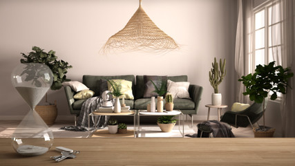 Wooden table, desk or shelf with crystal modern hourglass measuring passing time in a countdown to a deadline over vintage living room, interior design, copy space background