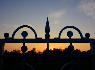 Gates hand made from a steel and evening sky in the background