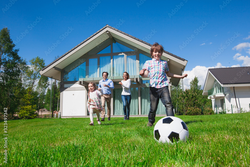 Wall mural Happy multi generation family playing football together in the park