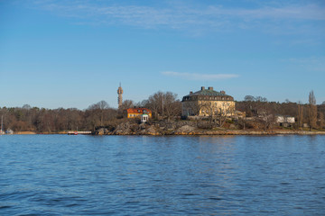 Stockholm waterfront, pale winter light over old house and a wind mill, Waldemarsudde, Sweden