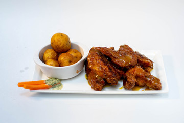 Chicken Wings with vegetables, dip and potatoes on white background 