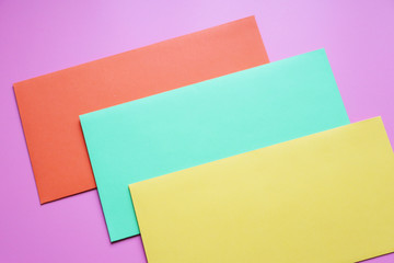 envelopes of different colors on a pink background. Copy space, celebration flat lay