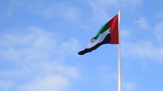 UAE flag waving in the sky, national symbol of UAE. UAE National Day. UAE flag day.