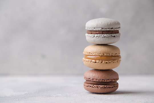 Macarons chocolate, caramel and vanilla on light background