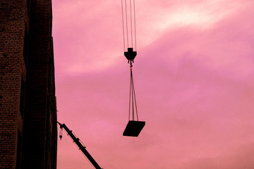 crane boom carries load on a construction site