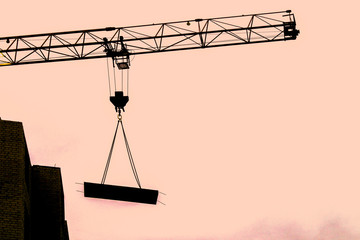 crane boom carries load on a construction site