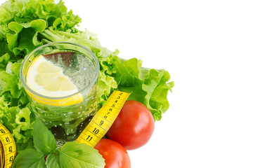 Pure drinking water with lemon, lettuce and tape measure. The concept of a healthy diet and drinking regime. Body cleansing and weight loss program. Copy space.