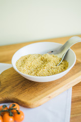 Uncooked bulgur in wooden bowl on wooden table background, rustic style. Bulgur wheat grains