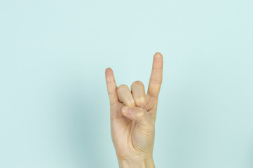 Symbol displayed by human hand isolated on a blue background.