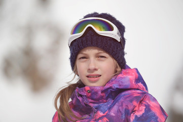 beautiful active smiling happy small young caucasian girl in woolen hat and snowboarding jacket...