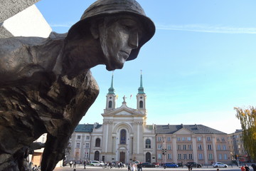 Soldatenstatue am Denkmal des Warschauer Aufstandes mit Heilig-Kreuz-Kirche im Hintergrund