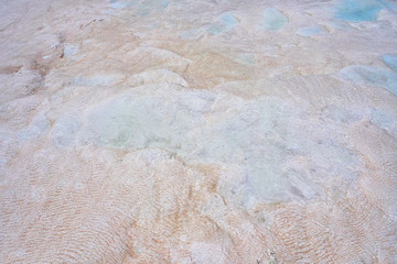 Undulatory texture of white calcite stalactites covering a cascade of terraced baths in Pamukkale, Turkey. Included in the UNESCO list of natural heritage.