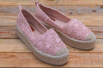 Espadrilles with rubber sole on wood background, close-up