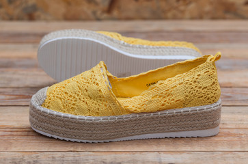 Espadrilles with rubber sole on wood background, close-up