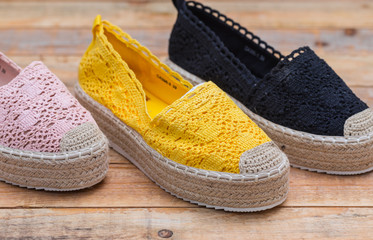 Espadrilles with rubber sole on wood background, close-up