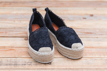 Espadrilles with rubber sole on wood background, close-up