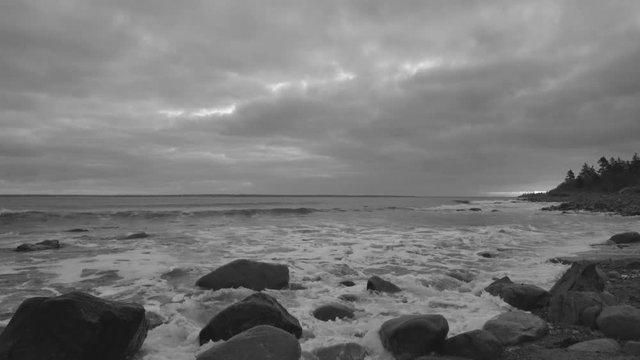 Beautiful morning at the rocky beach with gorgeous clouds and a glow in the sky