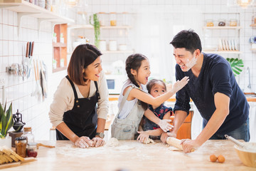 Asian family enjoy playing and cooking food in kitchen at home