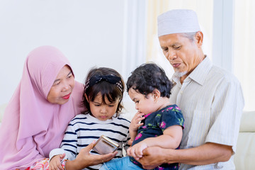 Elderly muslim parents lapping their grandchildren