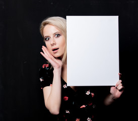 Blonde woman with white board on dark background